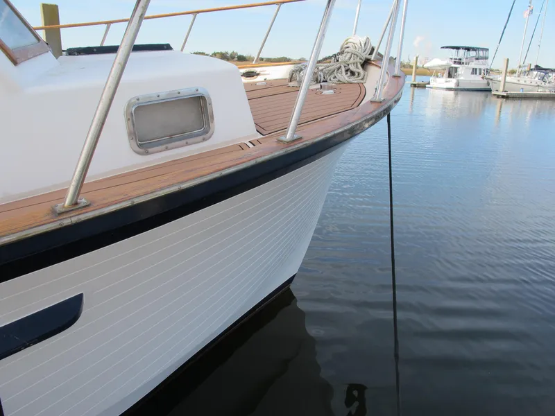 Slide: The Image of 1984 Monk 36 boat docked in calm marina waters. - 5