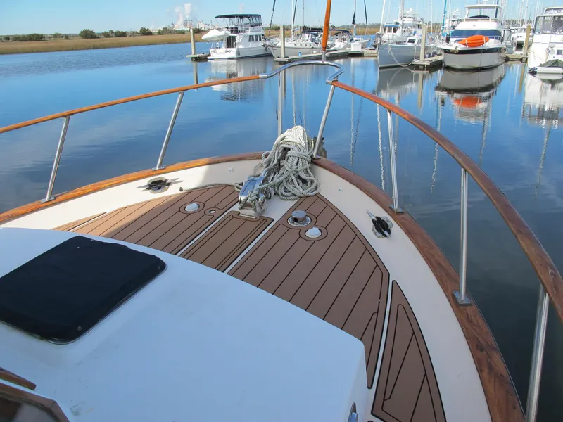 Slide: The Image of 1984 Monk 36 boat deck with ropes, docked in a marina with other boats. - 6