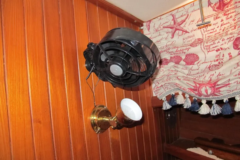 Slide: The Image of Wall-mounted fan and light fixture on a wooden panel in a 1984 Monk 36 boat. - 63