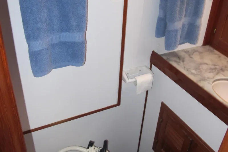 Slide: The Image of Bathroom interior of 1984 Monk 36 boat with blue towels and marble countertop. - 65