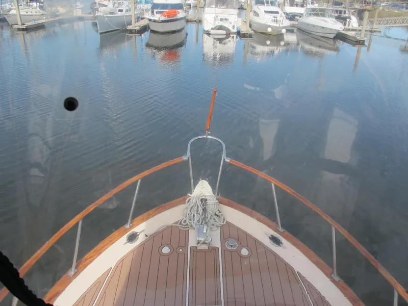 Slide: The Image of Bow view of 1984 Monk 36 yacht in a marina with calm waters. - 7