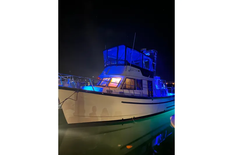 Slide: The Image of 1984 Monk 36 boat illuminated with blue lights at night on the water. - 75