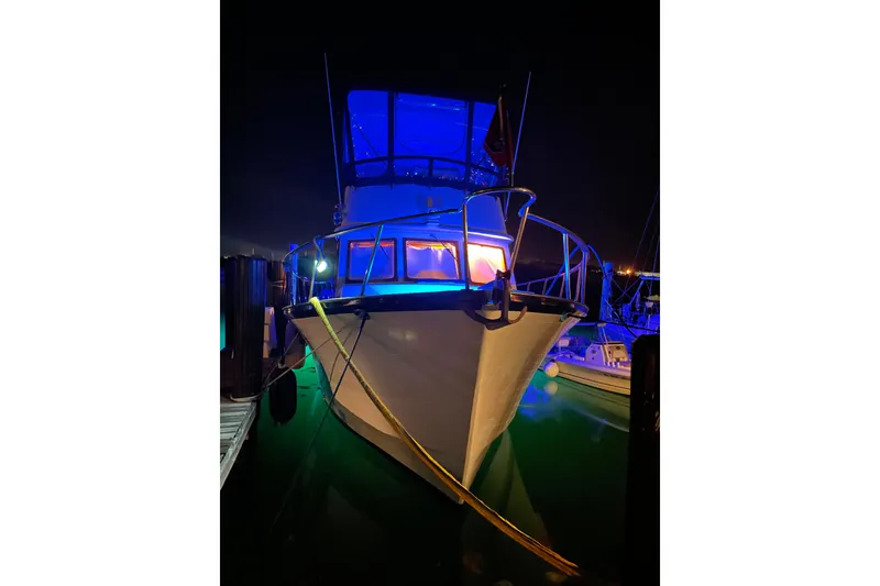 Slide: The Image of 1984 Monk 36 boat illuminated at night with blue and orange lights. - 76