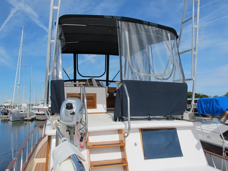 Slide: The Image of 1984 Monk 36 yacht with covered flybridge, docked at marina under clear blue sky. - 8