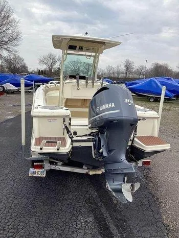 Slide: The Image of 2013 Scout 245 XFS boat with Yamaha 300 engine, parked outdoors. - 0