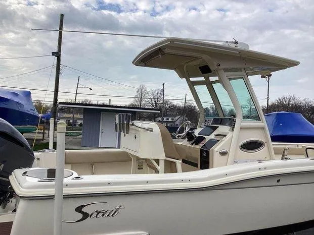 Slide: The Image of 2013 Scout 245 XFS boat with T-top and console, docked outdoors. - 6