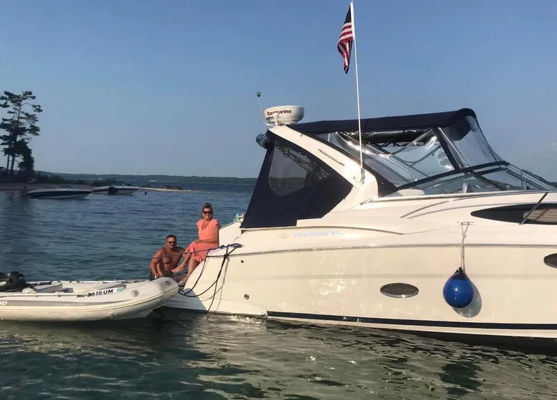 Slide: The Image of 2008 Regal 3360 Window Express boat anchored on a sunny lake with two people. - 3