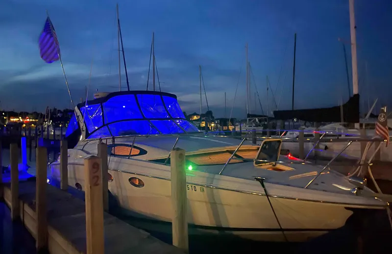Slide: The Image of 2008 Regal 3360 Window Express yacht docked at night with blue cabin lights. - 4