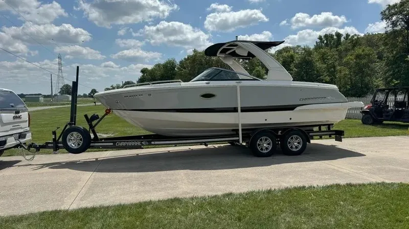 Slide: The Image of 2019 Chaparral 257 SSX boat on trailer, parked outdoors under a partly cloudy sky. - 10
