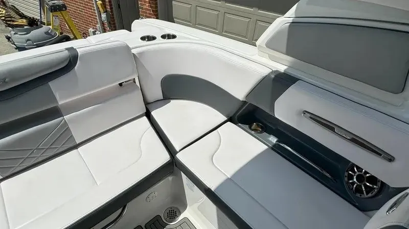 Slide: The Image of 2019 Chaparral 257 SSX boat interior with white and gray seating, cup holders, and speaker. - 13