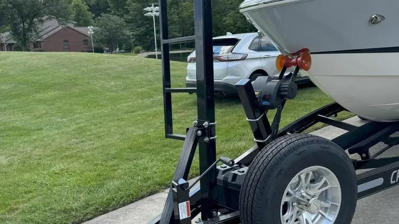 Slide: The Image of 2019 Chaparral 257 SSX boat on trailer, parked on driveway near grassy lawn. - 31