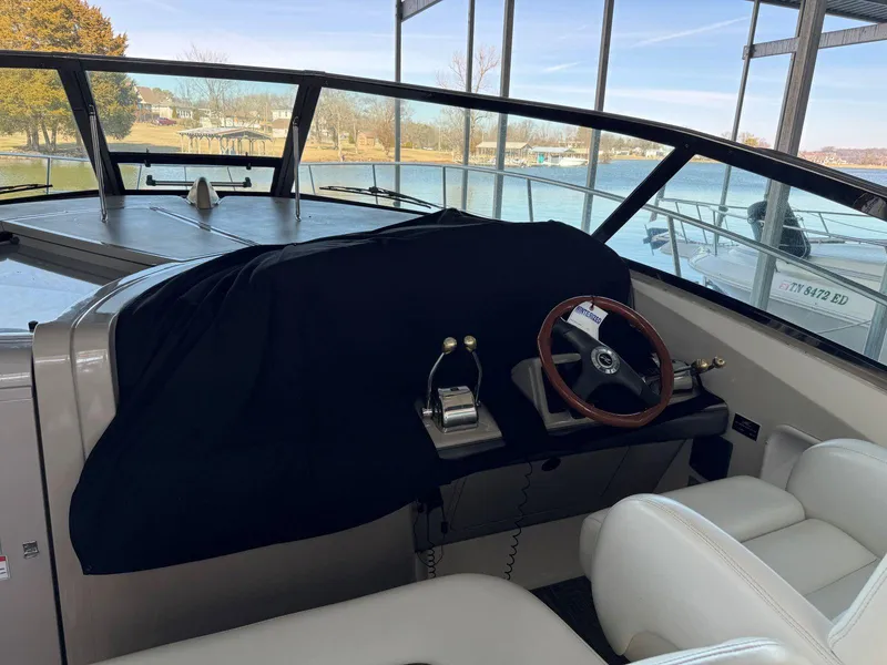 Slide: The Image of 2007 Sea Ray 38 Sundancer helm with covered dashboard and wooden steering wheel. - 13