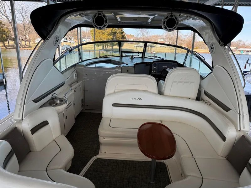 Slide: The Image of 2007 Sea Ray 38 Sundancer interior with white seating and helm, docked by the water. - 19