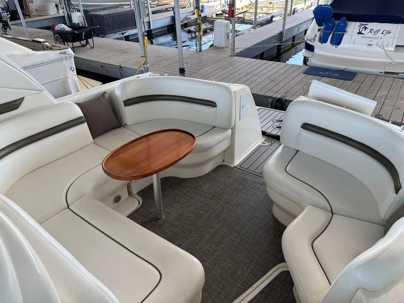 Slide: The Image of Luxurious 2007 Sea Ray 38 Sundancer yacht interior with white seating and wooden table. - 25