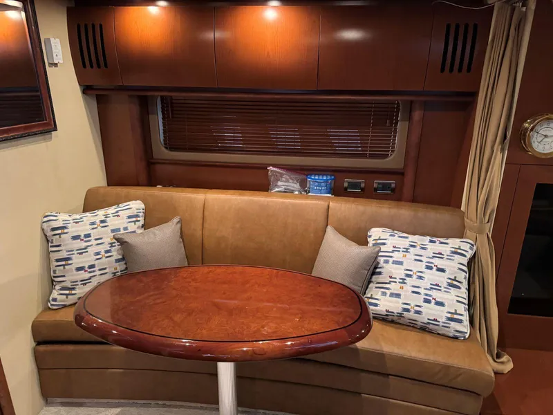 Slide: The Image of Interior of 2007 Sea Ray 38 Sundancer with leather seating and wooden table. - 49