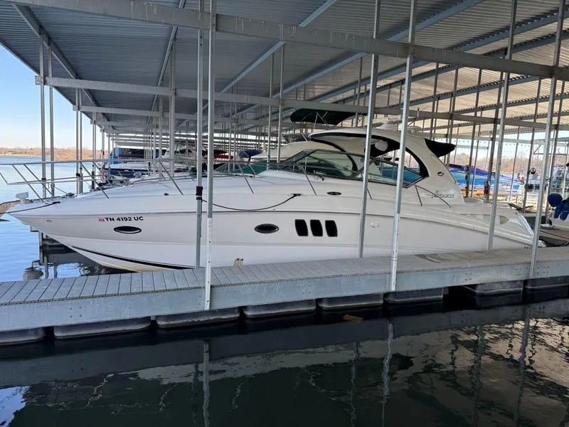Slide: The Image of 2007 Sea Ray 38 Sundancer docked in a marina under a covered slip. - 6