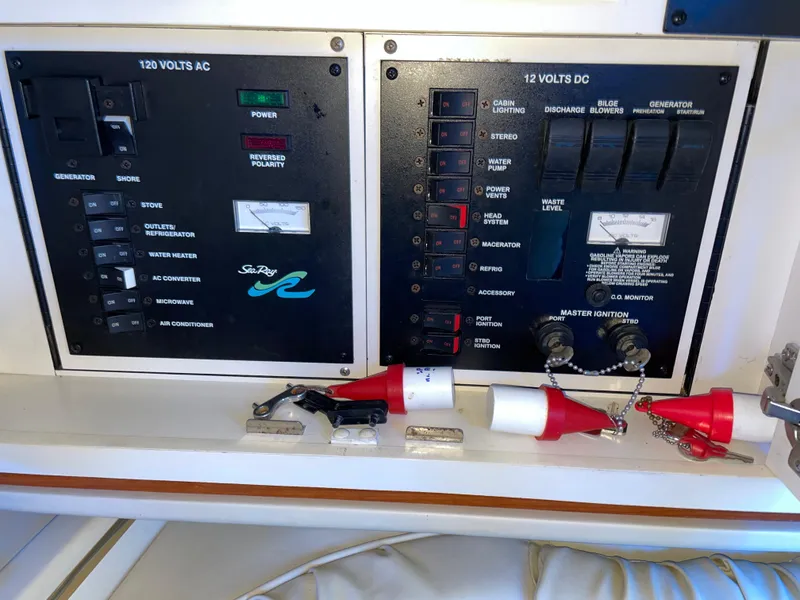 Slide: The Image of Electrical control panel on a 2000 Sea Ray 290 Amberjack boat, featuring AC and DC switches. - 23