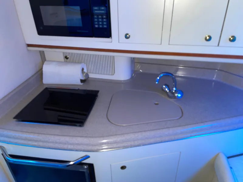 Slide: The Image of Compact kitchen area in a 2000 Sea Ray 290 Amberjack boat. - 24