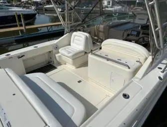 Slide: The Image of 2000 Sea Ray 290 Amberjack boat interior with white seating and dashboard, docked at marina. - 3