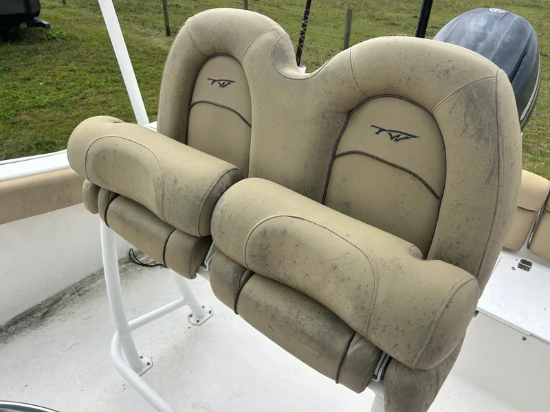 Slide: The Image of 2016 Tidewater 210 LXF boat seats, beige, slightly worn, on deck. - 13