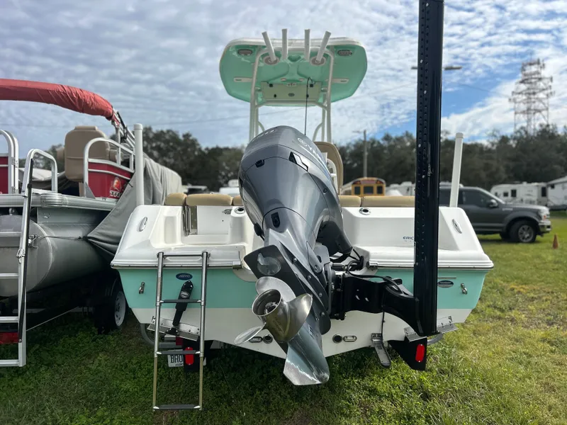 Slide: The Image of 2016 Tidewater 210 LXF boat with outboard motor, parked on grass under cloudy sky. - 3