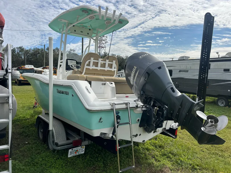Slide: The Image of 2016 Tidewater 210 LXF boat on trailer, featuring Yamaha outboard motor, parked outdoors. - 4