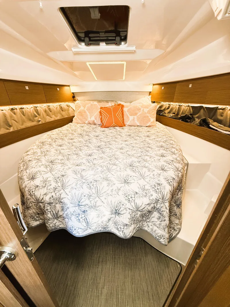 Slide: The Image of 2021 Jeanneau NC 895 cabin interior with cozy bed and decorative pillows. - 15