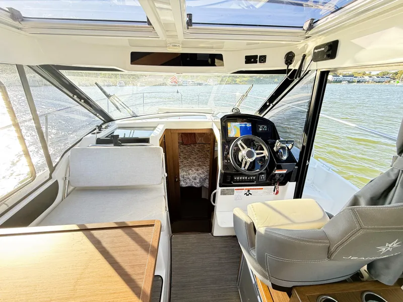 Slide: The Image of 2021 Jeanneau NC 895 boat interior with helm, seating, and cabin view. - 17