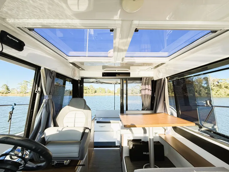 Slide: The Image of 2021 Jeanneau NC 895 boat interior with panoramic windows and seating area. - 22