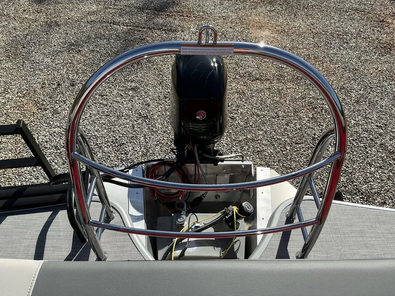 Slide: The Image of Lowe LS 170 boat engine, 2025 model, with protective railing on gravel surface. - 6