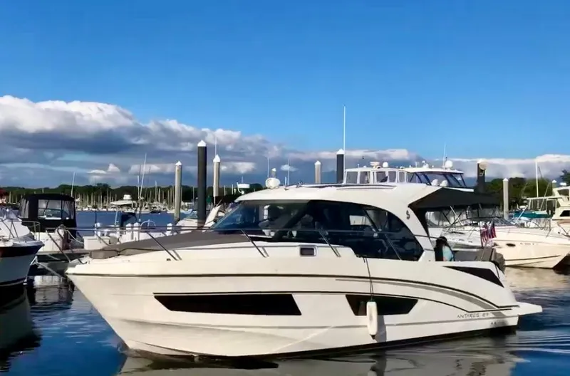 Slide: The Image of 2019 Beneteau Antares 27 boat docked in a marina under a clear blue sky. - 0