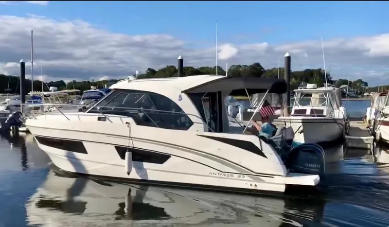 Slide: The Image of 2019 Beneteau Antares 27 boat docked in a marina, calm water, clear sky. - 1