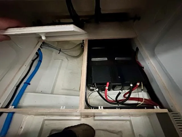 Slide: The Image of Battery compartment of a 2019 Beneteau Antares 27 boat, showing wiring and storage. - 12