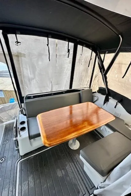 Slide: The Image of 2019 Beneteau Antares 27 boat interior with seating and wooden table. - 14