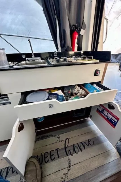 Slide: The Image of Interior of 2019 Beneteau Antares 27 showing kitchen storage and stove. - 17