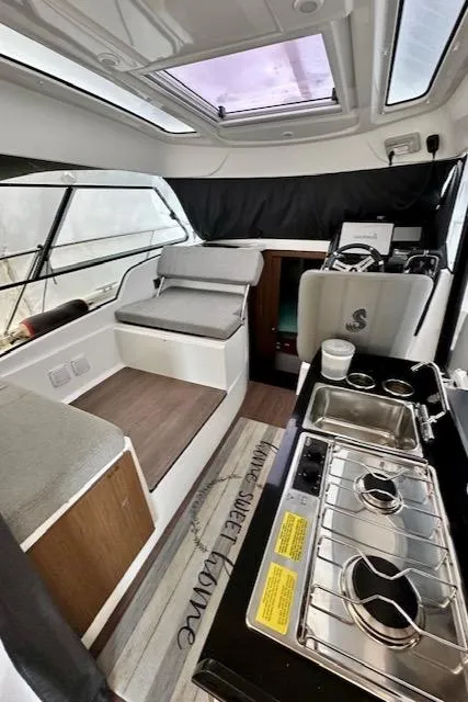 Slide: The Image of Interior of 2019 Beneteau Antares 27 boat with kitchen and seating area. - 2
