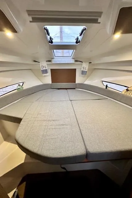 Slide: The Image of Interior cabin of a 2019 Beneteau Antares 27 with a spacious bed and skylight. - 25