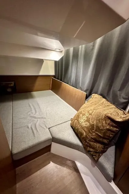 Slide: The Image of Cozy cabin interior of 2019 Beneteau Antares 27 with cushioned seating and decorative pillow. - 27