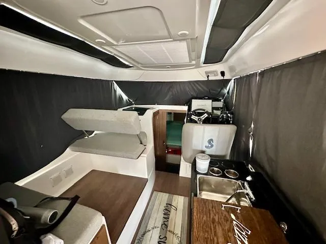 Slide: The Image of Interior of a 2019 Beneteau Antares 27 boat, featuring seating and kitchenette. - 29