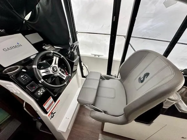 Slide: The Image of 2019 Beneteau Antares 27 helm with Garmin navigation, steering wheel, and captain's chair. - 3