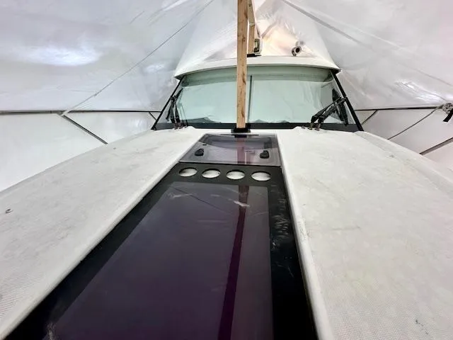 Slide: The Image of 2019 Beneteau Antares 27 boat under protective cover, showcasing front deck and windshield. - 30