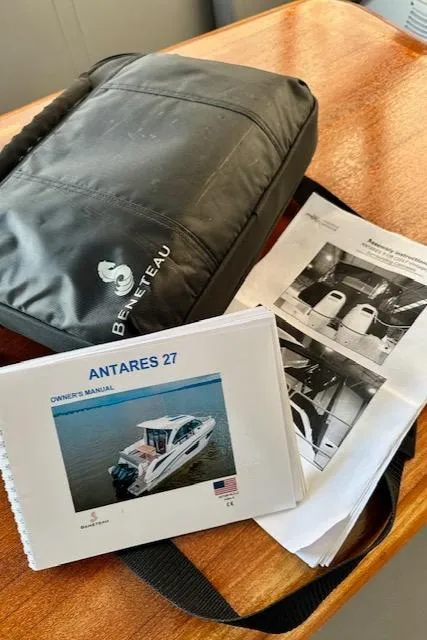 Slide: The Image of Beneteau Antares 27 owner's manual and bag on wooden table, 2019 model. - 41