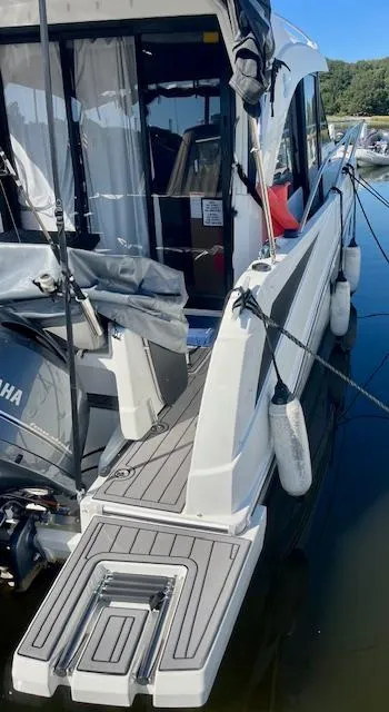 Slide: The Image of 2019 Beneteau Antares 27 docked, showcasing rear deck and motor, with fenders attached. - 42