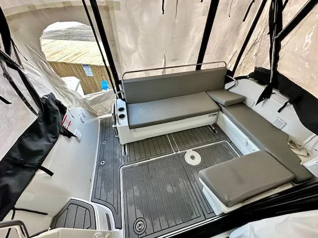 Slide: The Image of 2019 Beneteau Antares 27 boat interior with cushioned seating and protective cover. - 5