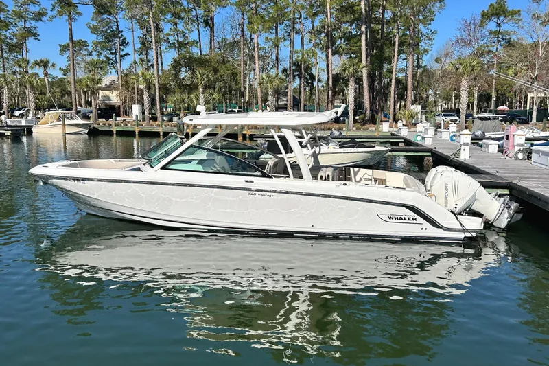 Slide: The Image of 2017 Boston Whaler 320 Vantage boat docked in a serene marina setting. - 0