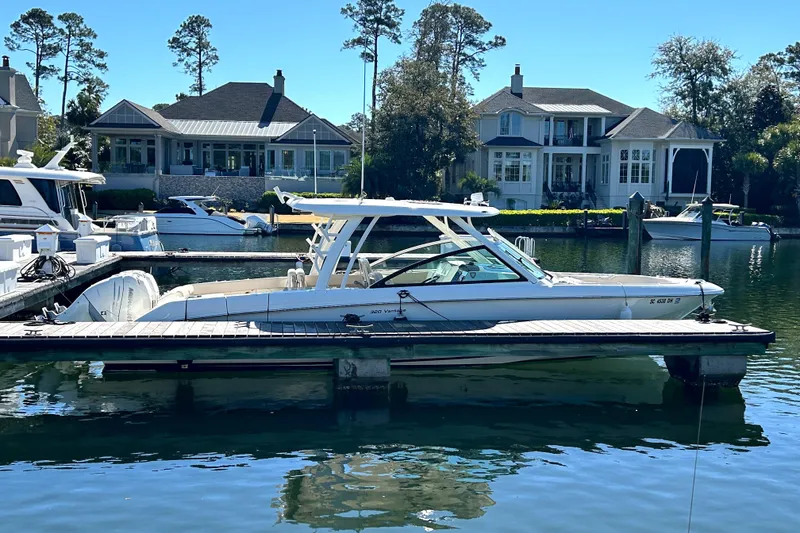 Slide: The Image of 2017 Boston Whaler 320 Vantage docked in a scenic marina with waterfront homes. - 1