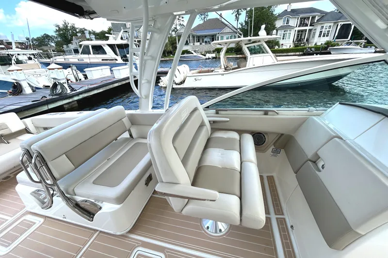 Slide: The Image of 2017 Boston Whaler 320 Vantage interior with luxurious seating at a marina. - 17