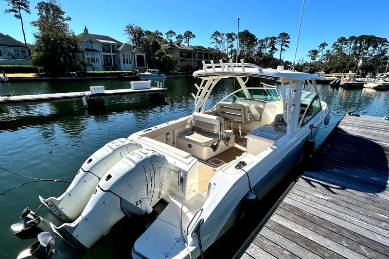 Slide: The Image of 2017 Boston Whaler 320 Vantage docked in a scenic marina setting. - 2