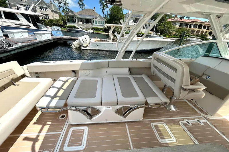 Slide: The Image of 2017 Boston Whaler 320 Vantage boat interior with seating, docked near waterfront homes. - 20