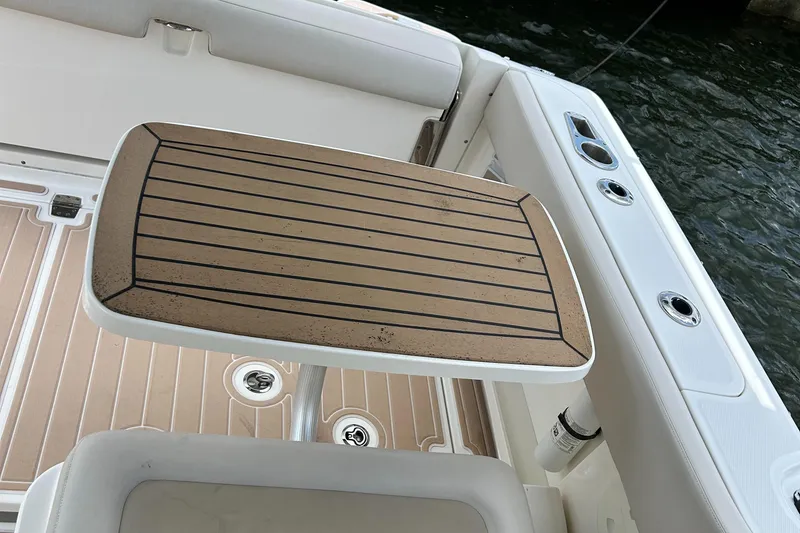 Slide: The Image of Boston Whaler 320 Vantage 2017 boat interior with wooden table and seating. - 23